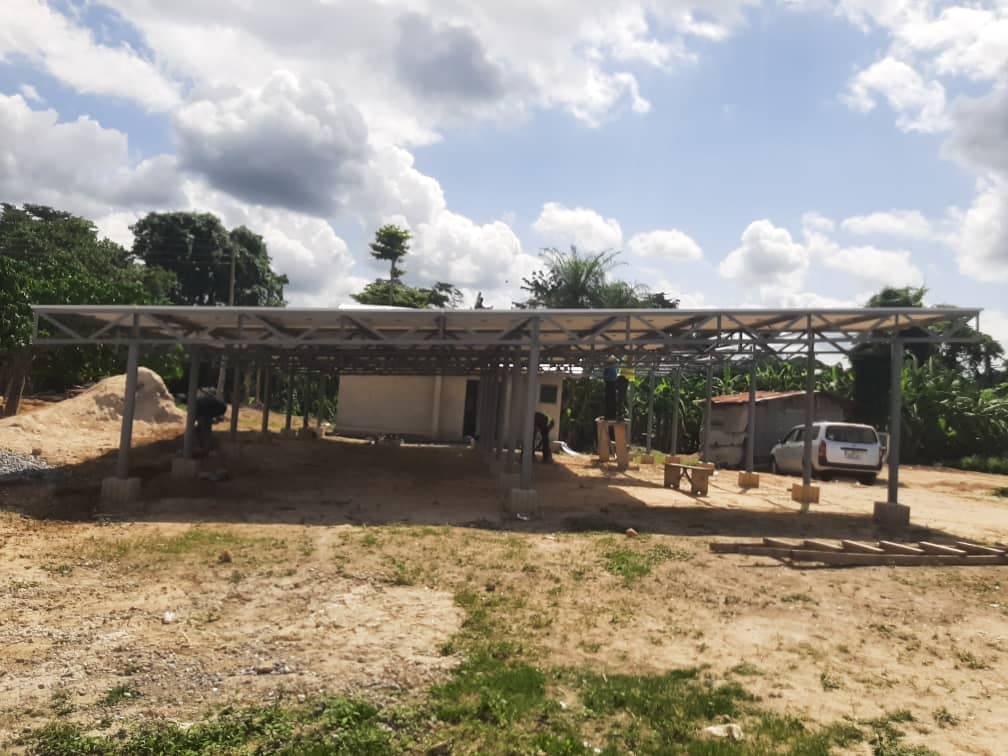 Steel mounting frame for the Onaa solar mini-grid under construction, with workers on site